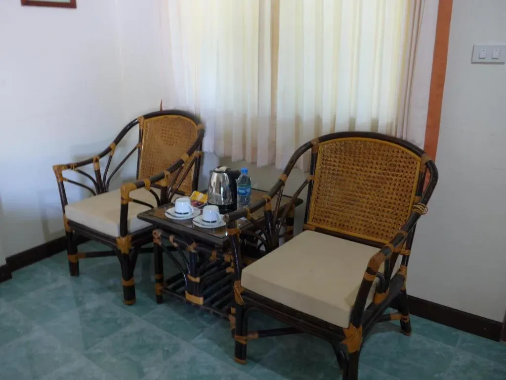 Cozy covered terrace lounge area with rattan chairs at Forum House Hotel