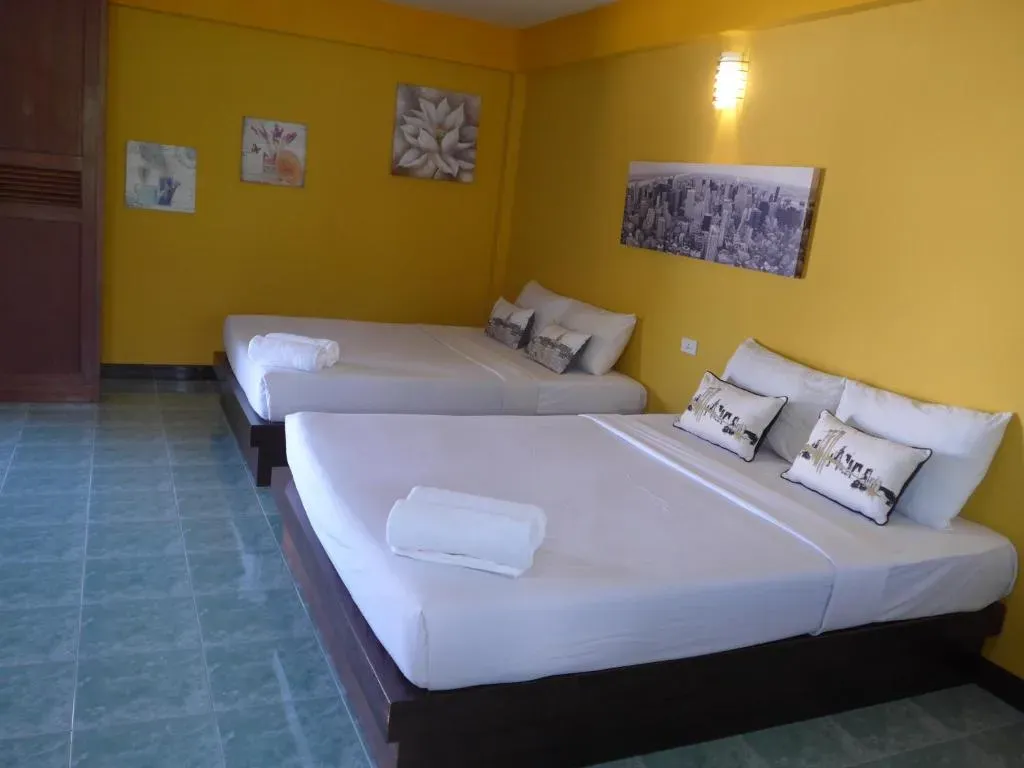 Bright guest room at Forum House Hotel with a yellow accent wall and comfortable beds
